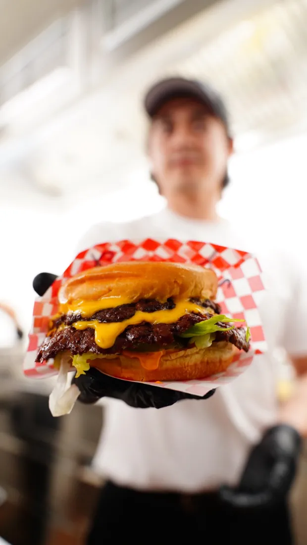 Fertiger Double-Smash-Burger mit krossen Rändern im Papierkorb